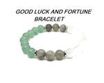Handmade gemstone bracelet with good luck and fortune charms, featuring colorful beads and a natural gemstone design.