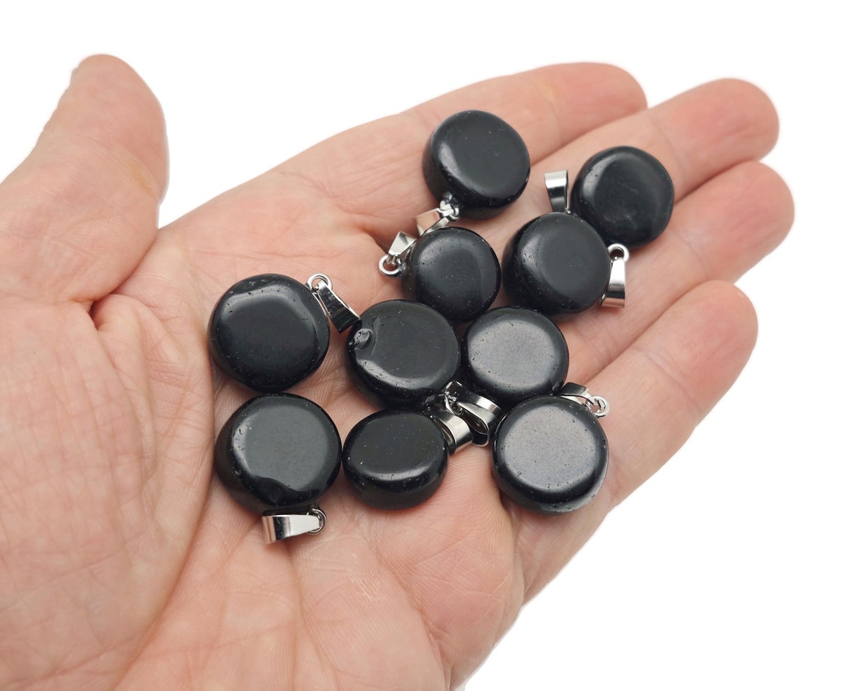 Obsidian flat round gemstone pendant with a polished crystal coin shape, showcasing a smooth black surface and silver bail.