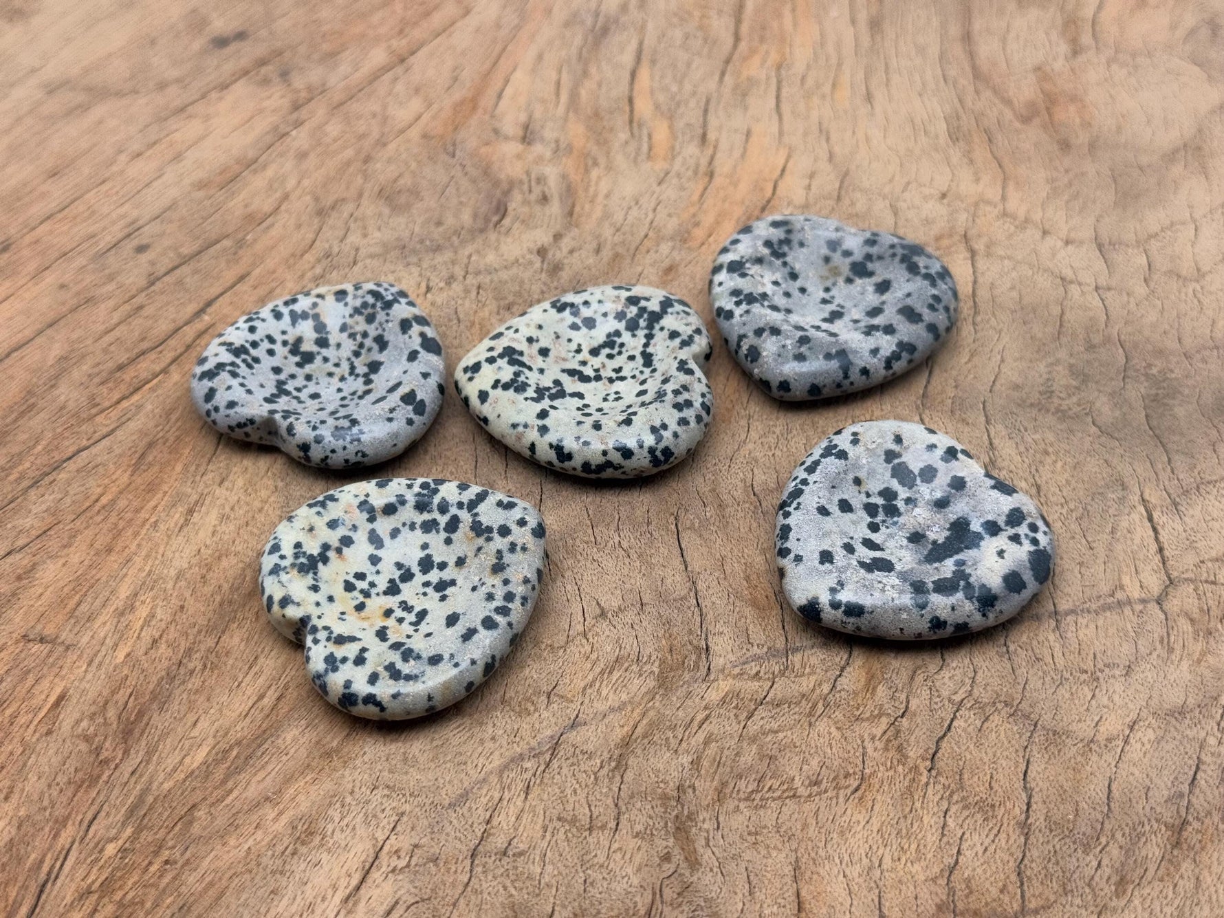 Dalmatian Jasper heart worry stone from GemstoneGO, a soothing crystal with black spots on a cream background, used for stress relief.