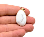 Dainty Howlite gold gemstone pendant from GemstoneGO with a polished white stone and gold-tone bail, suitable for jewelry DIY charms.