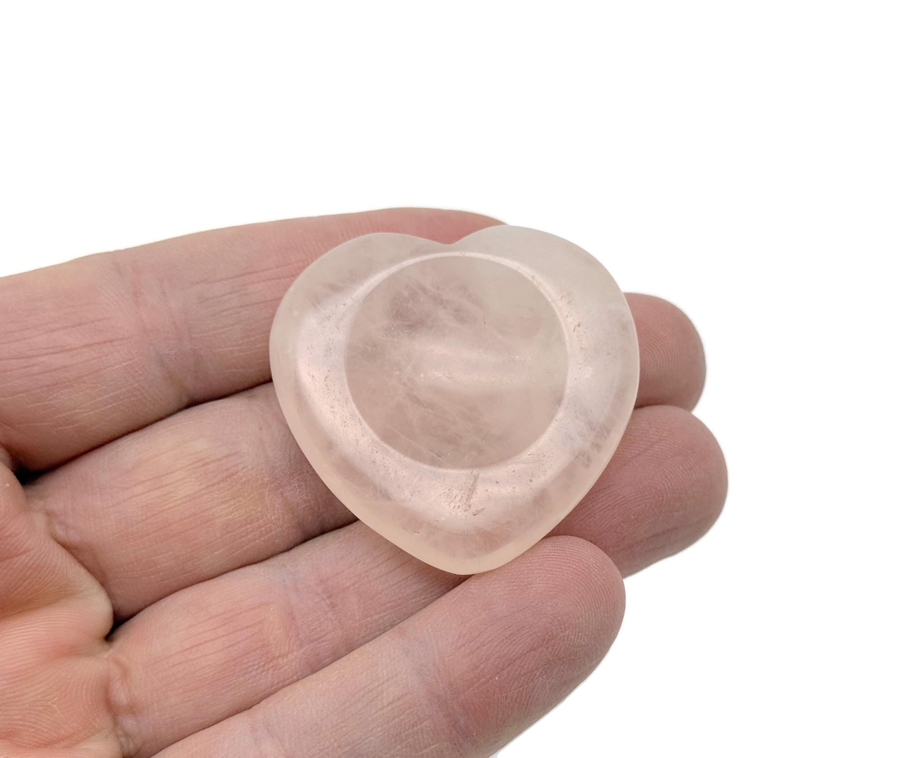 Rose quartz heart worry stone from GemstoneGO, a soothing crystal for stress relief and emotional healing, shown in close-up.