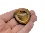 Tiger Eye heart worry stone from GemstoneGO, a soothing crystal for stress relief and meditation, shown in close-up.
