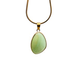 Dainty Amazonite gemstone pendant with gold setting, showcasing a natural blue-green stone on a jewelry display.