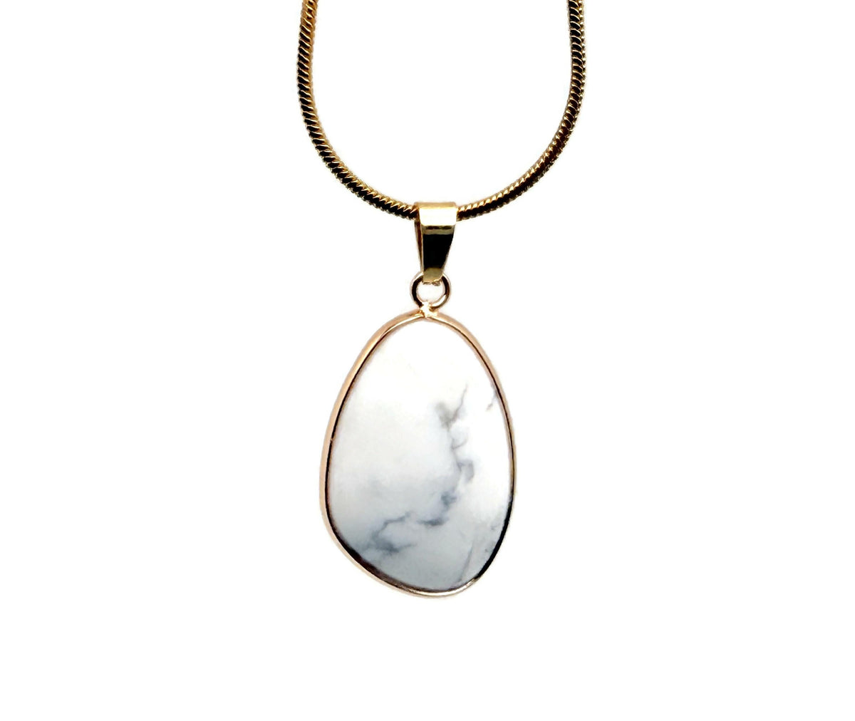 Dainty Howlite gemstone pendant with gold accents, ideal for DIY jewelry charms, showcasing a smooth, polished stone.