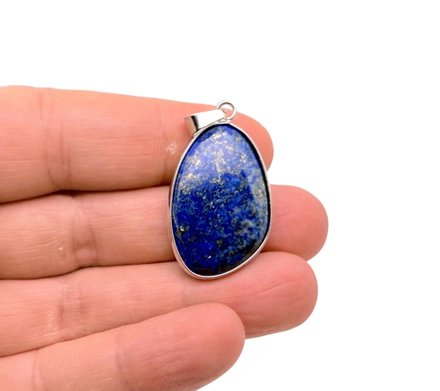 Dainty silver lapis lazuli gemstone pendant with gold accents, showcasing a polished blue stone and intricate design.