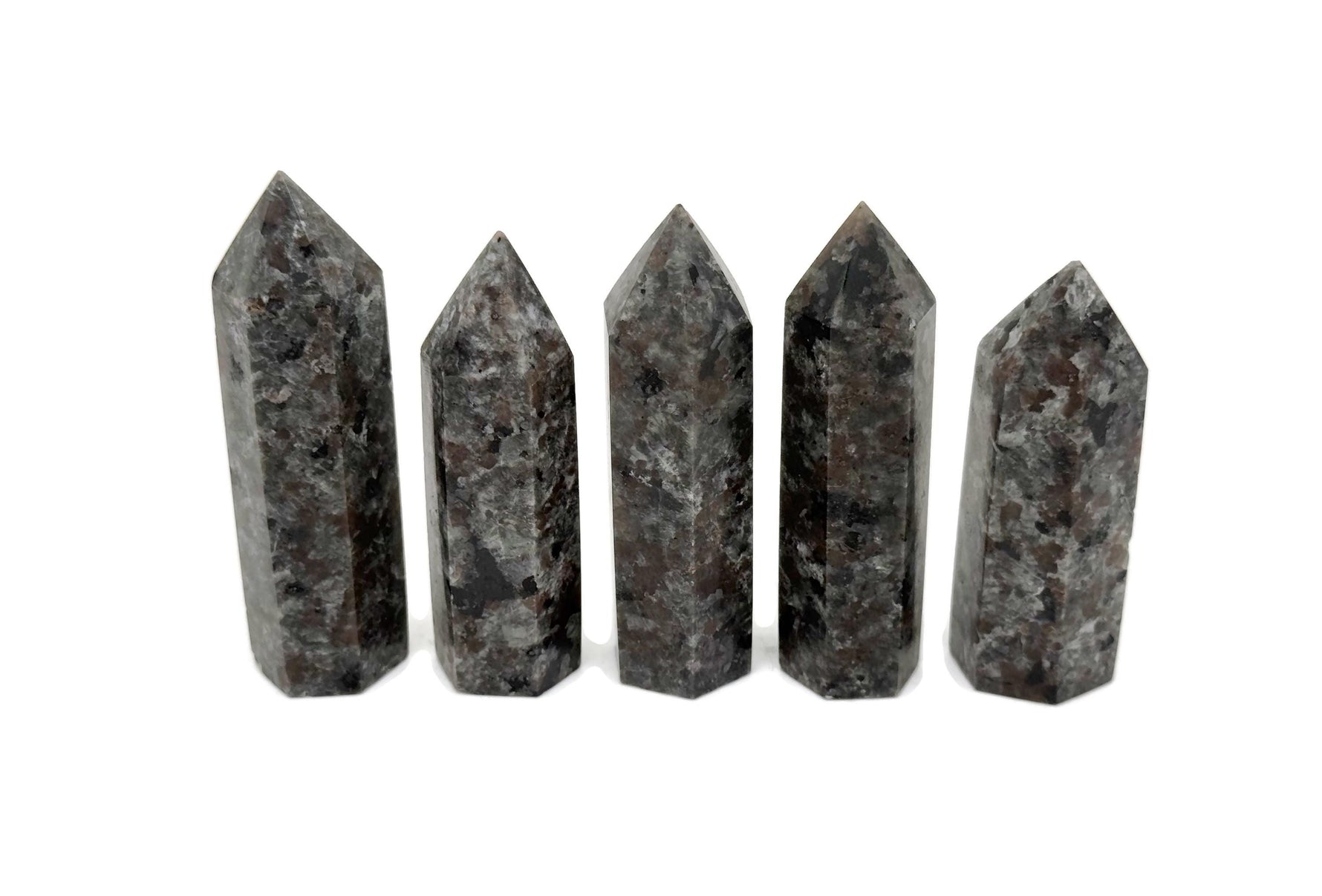 Yooperlite obelisk tower crystal featuring fluorescent sodalite stone with vibrant blue and purple hues, displayed against a neutral background.