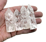 Cracked clear quartz obelisk tower crystal from GemstoneGO, showcasing a tall, pointed stone with natural internal fractures.