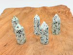 Kiwi Jasper obelisk tower crystal from GemstoneGO showing a tall, polished green and tan gemstone obelisk with natural patterning.