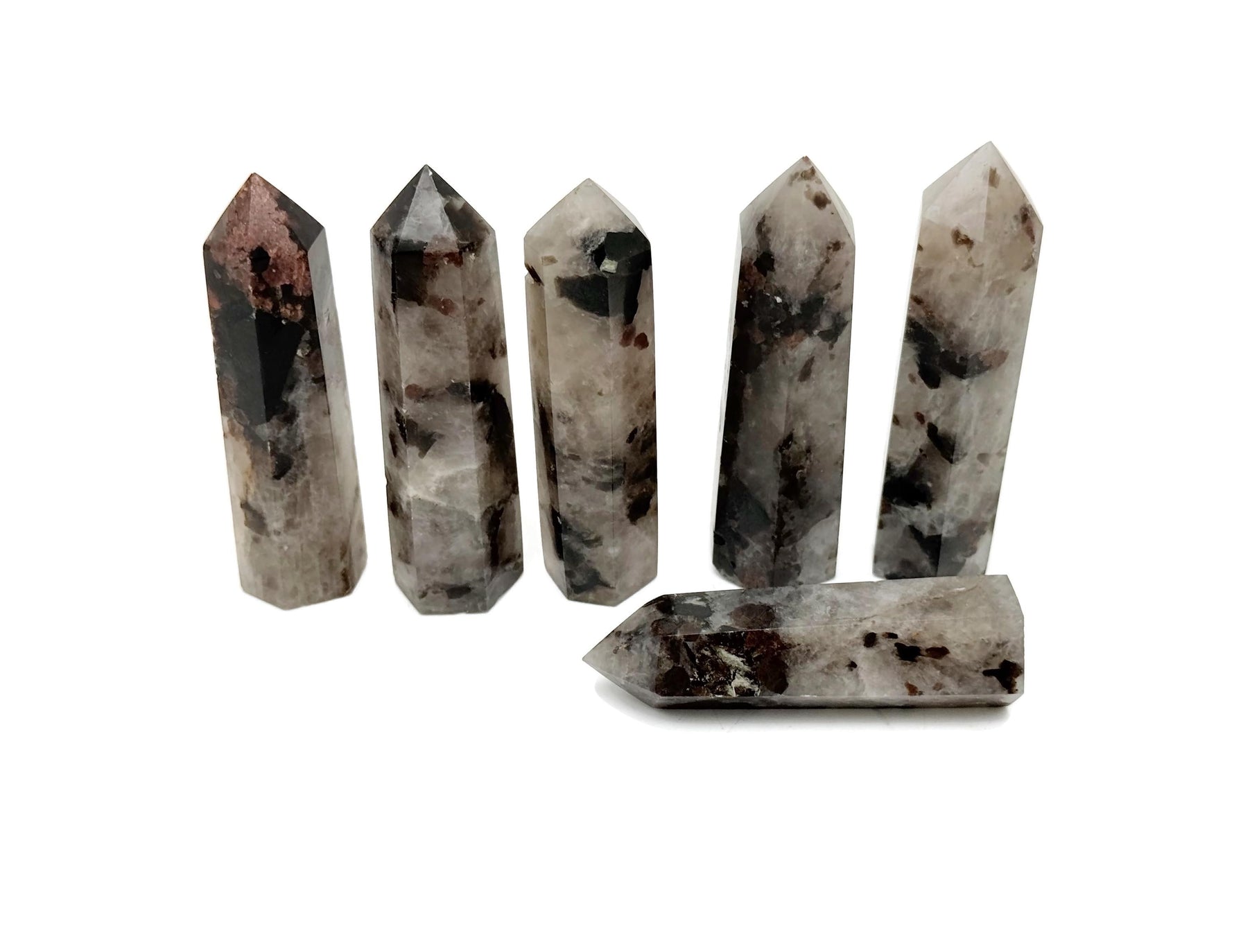 Garnet and black tourmaline obelisk tower crystal from GemstoneGO, showcasing polished stones with intricate natural patterns.