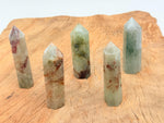 Green rutilated quartz obelisk tower crystal from GemstoneGO with natural mineral inclusions and a polished pointed shape.