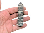 Red Zebra Calcite obelisk tower crystal by GemstoneGO, showcasing vibrant red and white striped mineral with a polished finish.