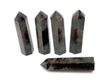 Garnet obelisk tower crystal by GemstoneGO, showcasing a deep red gemstone carved into a tall, pointed obelisk shape.