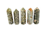 Rhyolite obelisk tower crystal in rainforest colors, gemstone sculpture by GemstoneGO on a white background.