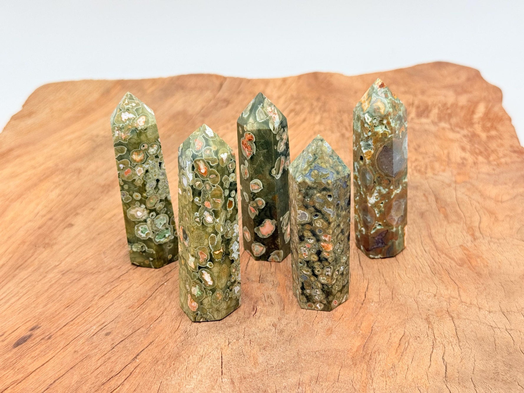Rhyolite obelisk tower crystal from GemstoneGO featuring vibrant rainforest colors and polished surface.