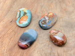 Ocean Jasper palm gemstone spa stone from GemstoneGO, showing a smooth, polished natural ocean-colored orb for healing and relaxation.