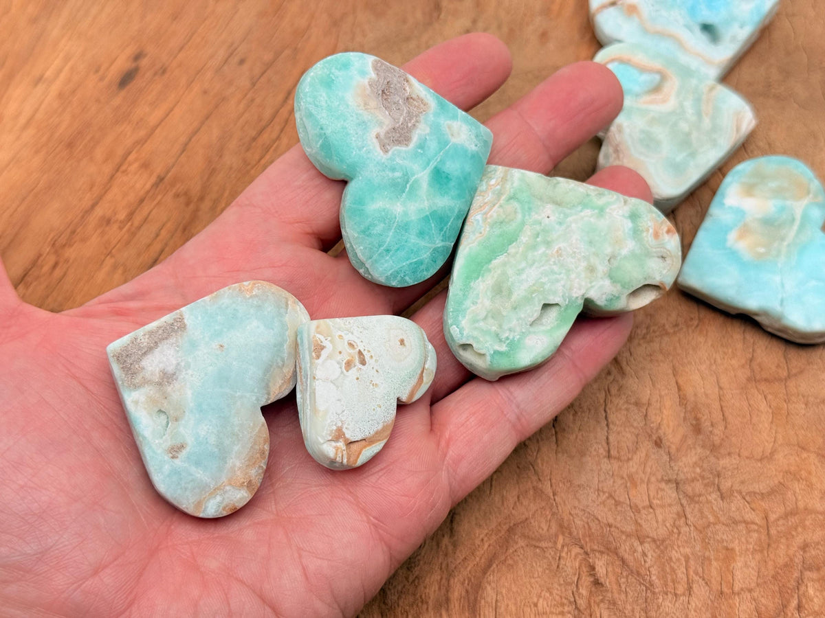 Caribbean calcite heart-shaped gemstone from GemstoneGO, showcasing vibrant orange and yellow hues with polished surface.