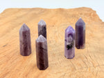 Lepidolite obelisk crystal tower from GemstoneGO, showcasing a purple and silver-toned mineral with natural striations.