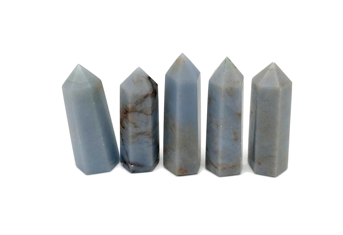 Angelite obelisk tower crystal from GemstoneGO, showing a smooth, pale blue gemstone with natural stone texture and pointed shape.