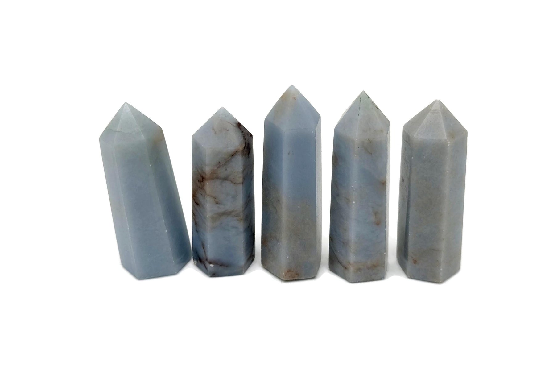 Angelite obelisk tower crystal from GemstoneGO, showing a smooth, pale blue gemstone with natural stone texture and pointed shape.