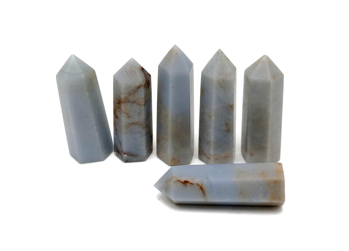 Angelite obelisk tower crystal from GemstoneGO, showcasing a smooth, pale blue gemstone with natural veining and pointed shape.