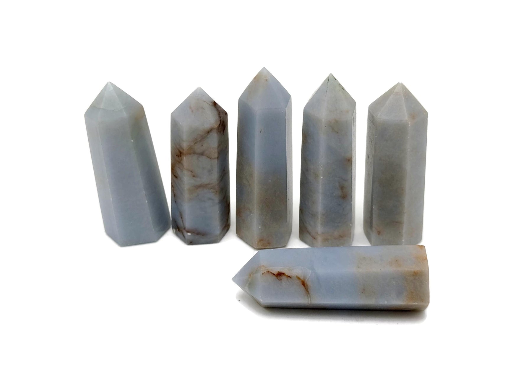 Angelite obelisk tower crystal from GemstoneGO, showcasing a smooth, pale blue gemstone with natural veining and pointed shape.