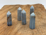 Angelite obelisk tower crystal from GemstoneGO, showcasing smooth pale blue stone with natural veining and pointed shape.