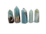 Caribbean calcite obelisk tower crystal from GemstoneGO, featuring a polished, pointed crystal structure in warm orange and yellow hues.