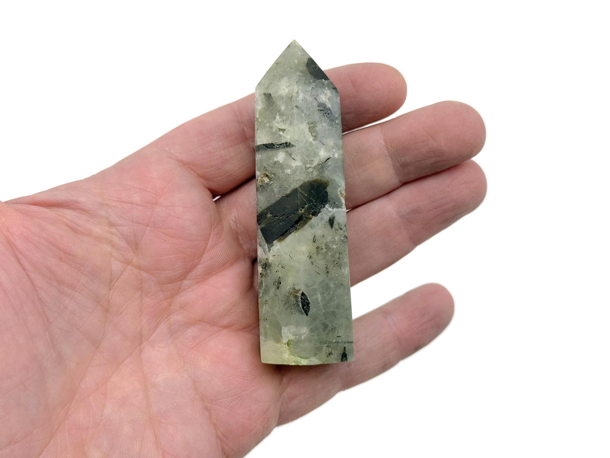 Prehnite obelisk tower crystal from GemstoneGO showcasing a smooth green mineral with natural stone textures and polished surfaces.