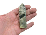 Prehnite obelisk tower crystal from GemstoneGO showcasing a smooth green mineral with natural stone textures and polished surfaces.