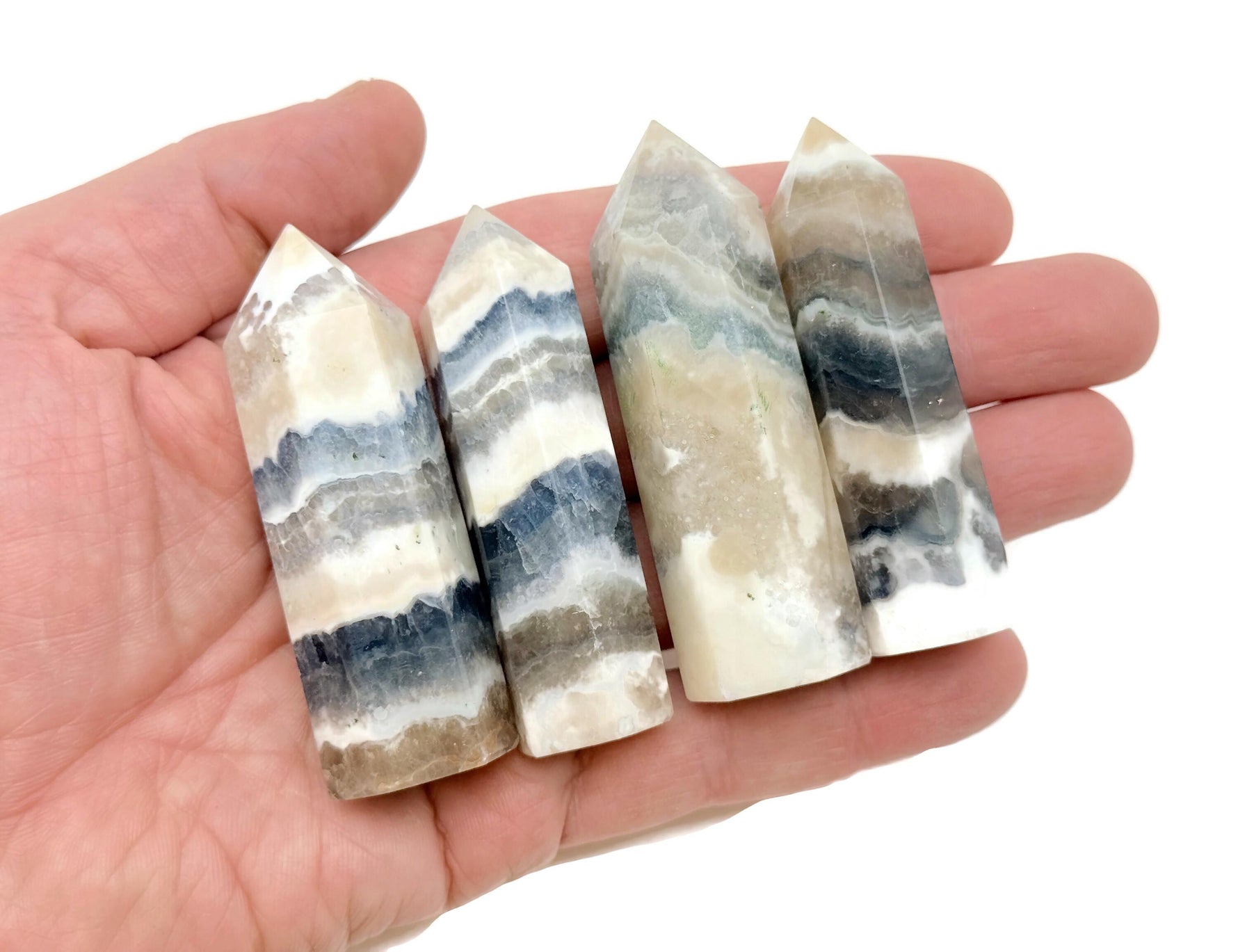 Fluorescent fluorite agate obelisk tower crystal with vibrant purple and green hues, displayed on a white background.