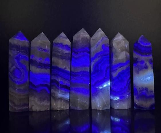 Fluorescent fluorite agate obelisk tower crystal from GemstoneGO, showcasing vibrant green and purple hues with natural banding.
