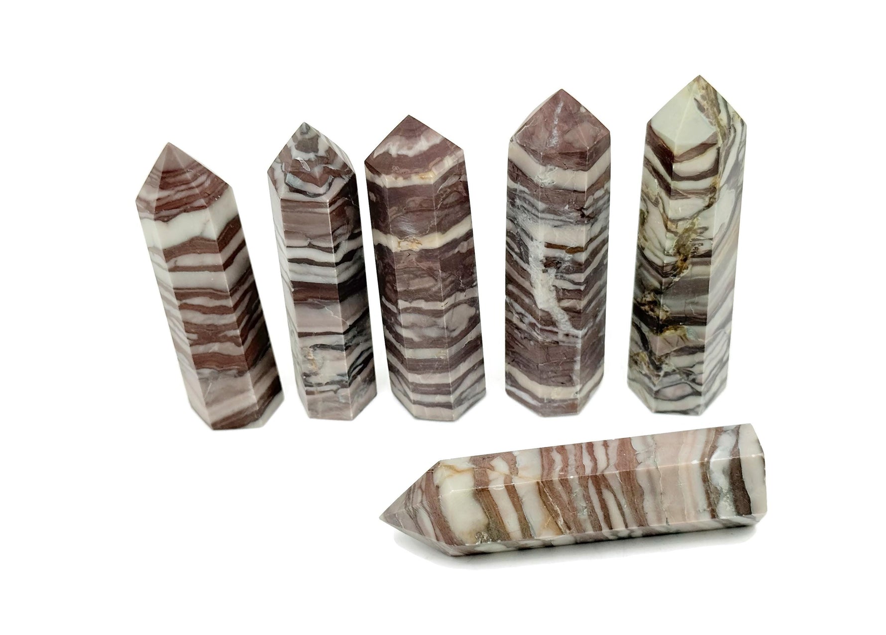Red zebra calcite obelisk tower crystal from GemstoneGO, featuring vibrant red and white striped mineral formation.