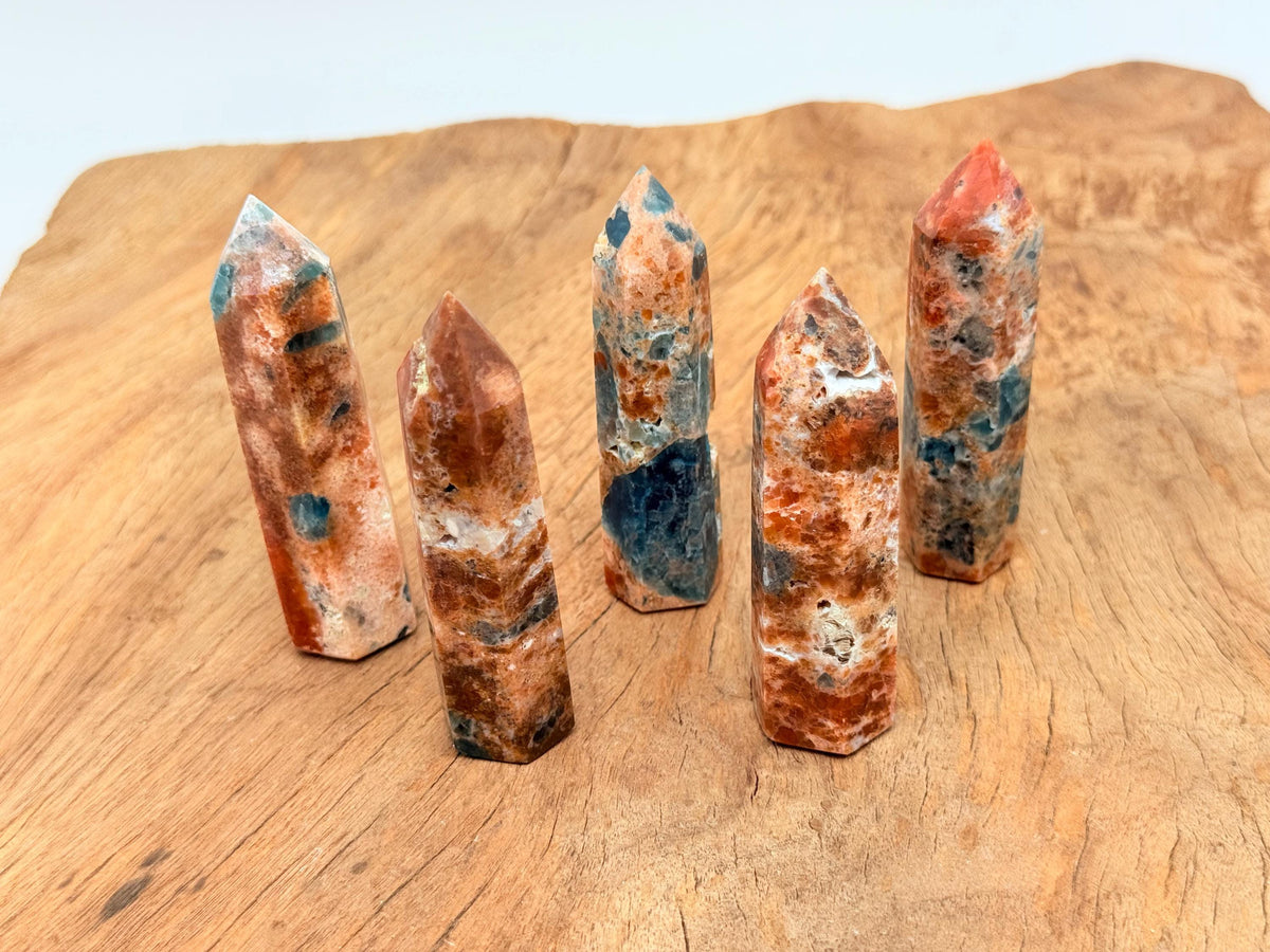 Sunstone and blue apatite obelisk tower crystal, crafted by GemstoneGO, featuring vibrant orange and blue mineral hues.