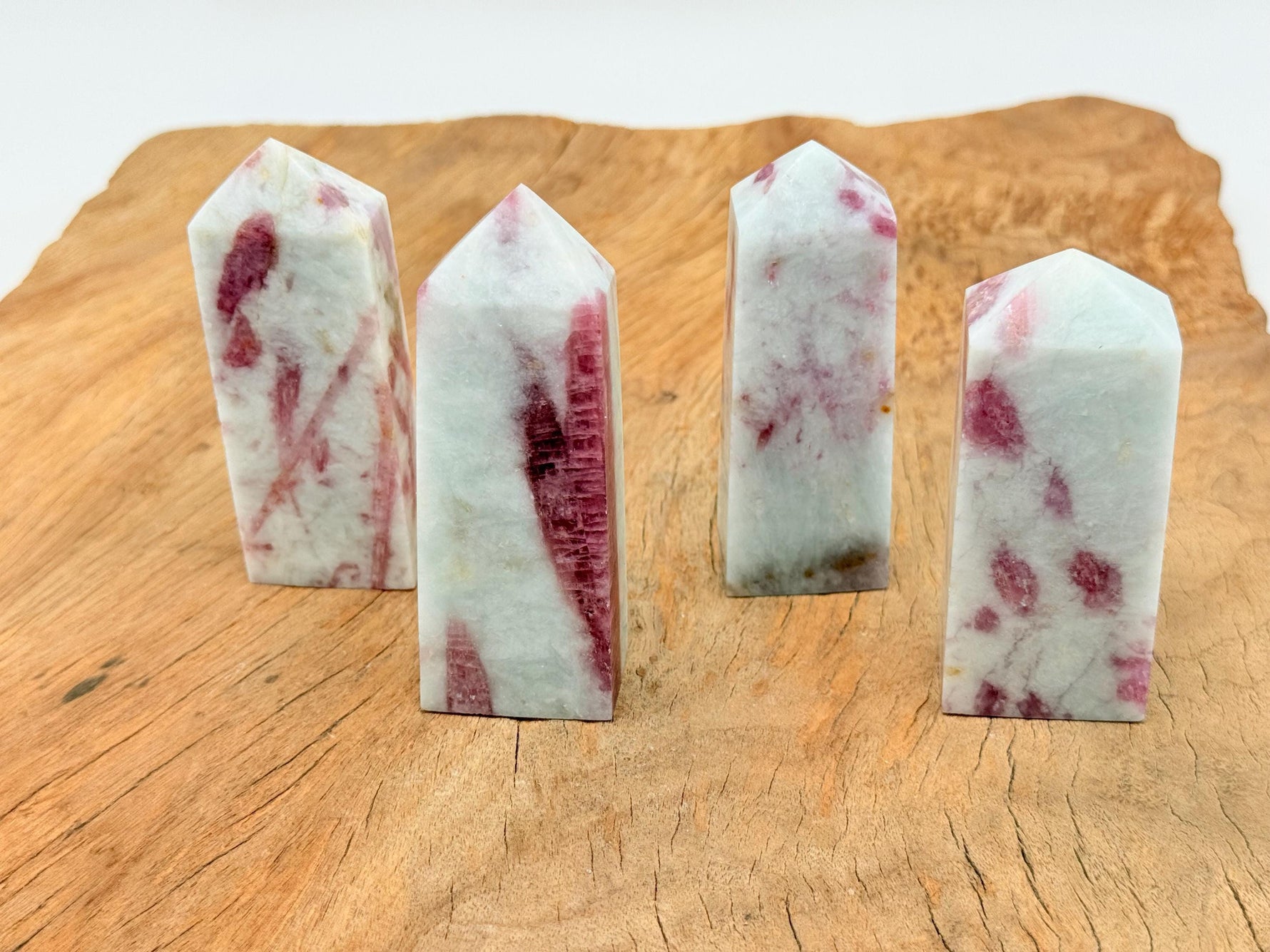Pink Tourmaline obelisk tower crystal from GemstoneGO, showcasing a polished pink gemstone with natural striations and a pointed top.