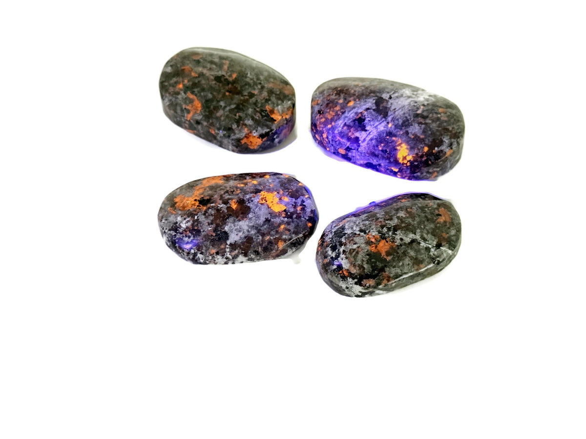Yooperlite palm gemstone displaying fluorescent sodalite spa stone with vibrant blue glow, perfect for meditation and relaxation.