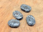 Yooperlite Palm Gemstone with fluorescent sodalite, spa stone from GemstoneGO, showcasing glowing blue and white mineral patterns.