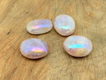 Angel Aura Quartz palm gemstone spa stone by GemstoneGO, showing iridescent, smooth, polished quartz with vibrant rainbow hues.