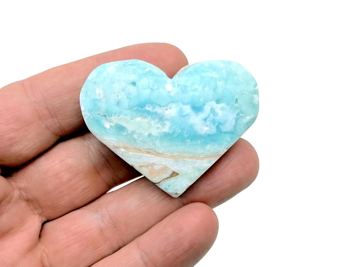 Caribbean Calcite Heart gemstone from GemstoneGO, polished pink-orange mineral with smooth rounded shape and vibrant color.