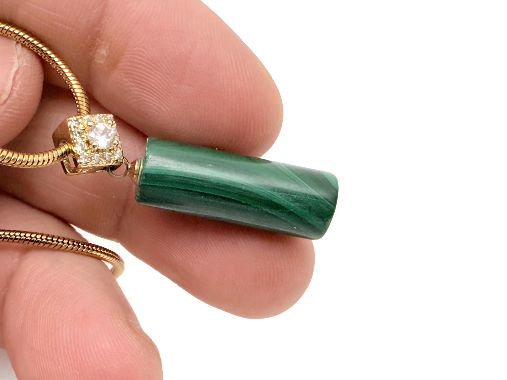 Malachite cylinder crystal pendant necklace with gold chain, showcasing protective and powerful gemstone jewelry.