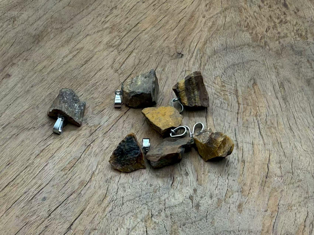 Tiger Eye crystal pendant from GemstoneGO, showing a polished oval gemstone with a metal bail for jewelry making.