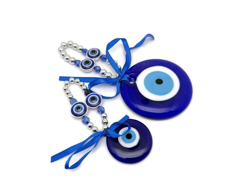 Blue glass evil eye charm with intricate design, Turkish Nazar amulet for protection and healing, ideal for home decor.