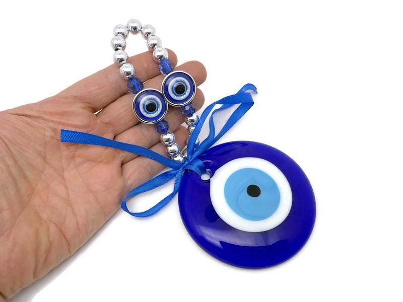 Blue glass evil eye charm with intricate Turkish design, symbolizing protection and healing for home decor and jewelry.