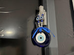 Blue glass evil eye charm from GemstoneGO, featuring traditional Turkish Nazar design, used as a healing or home decor gift.