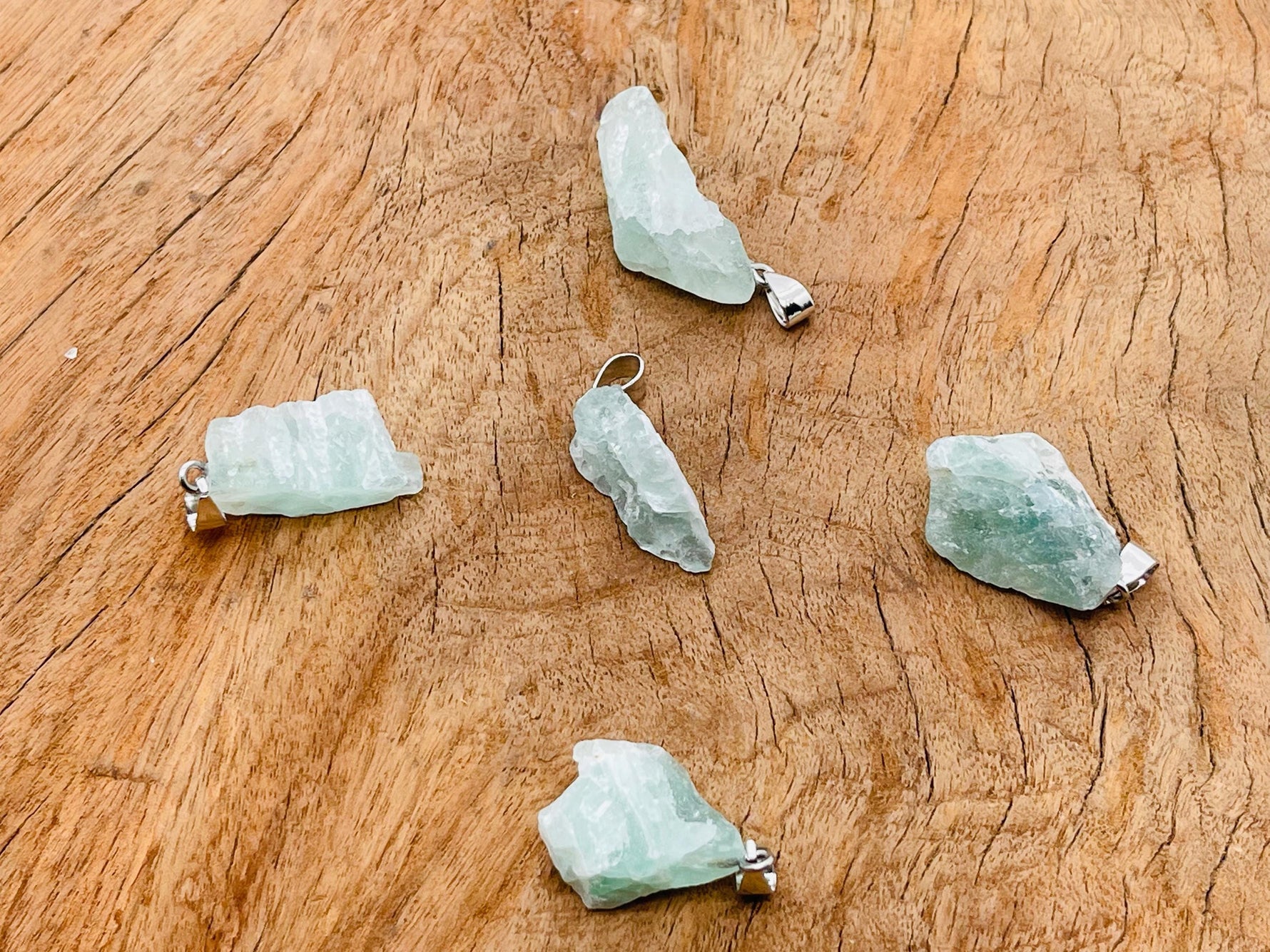 Fluorite crystal pendant from GemstoneGO featuring a vibrant green and purple gemstone on a silver chain.