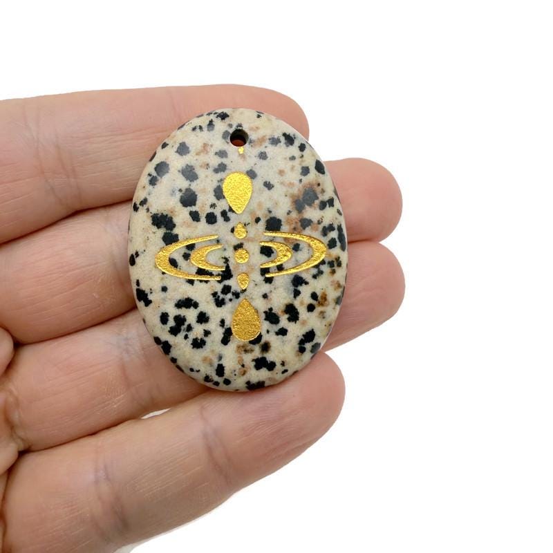 Drilled cosmic energy symbol engraved crystal amulet by GemstoneGO, featuring universe alignment design on a clear crystal pendant.