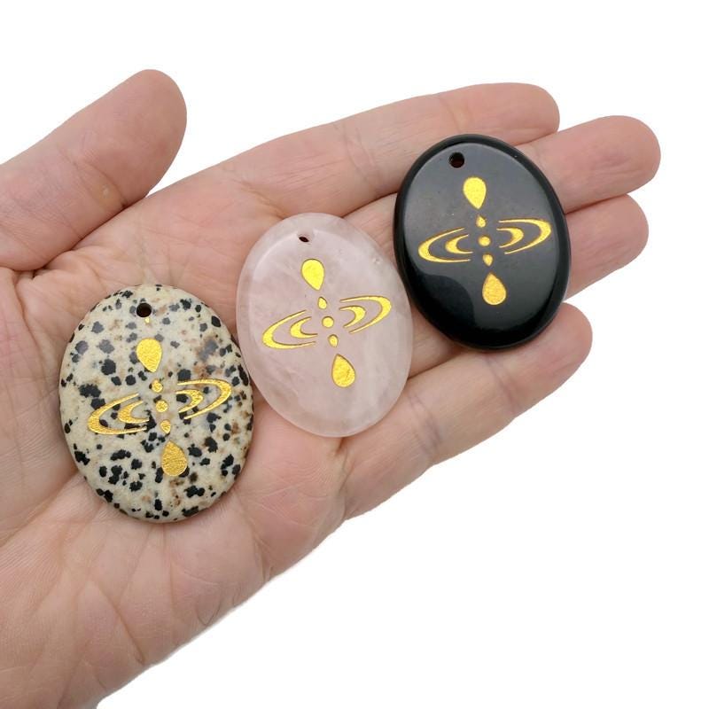 Drilled cosmic energy symbol engraved crystal amulet by GemstoneGO, featuring universe alignment design on a clear crystal pendant.
