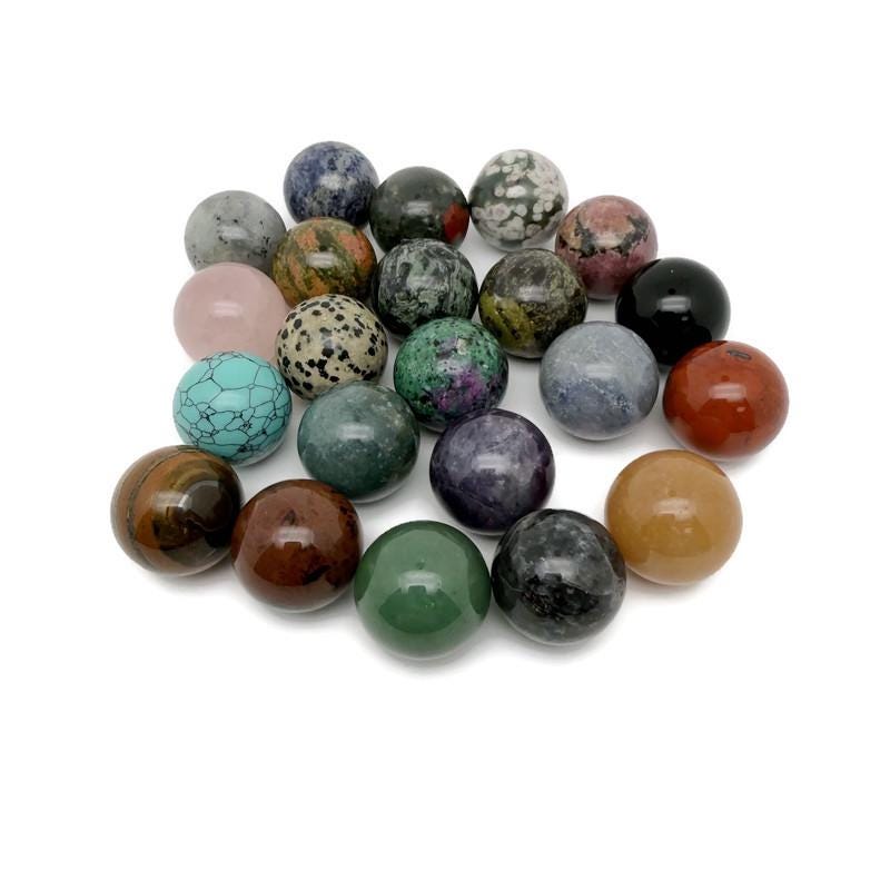 25mm natural crystal sphere by GemstoneGO, showcasing a clear, polished gemstone ball on a neutral background.