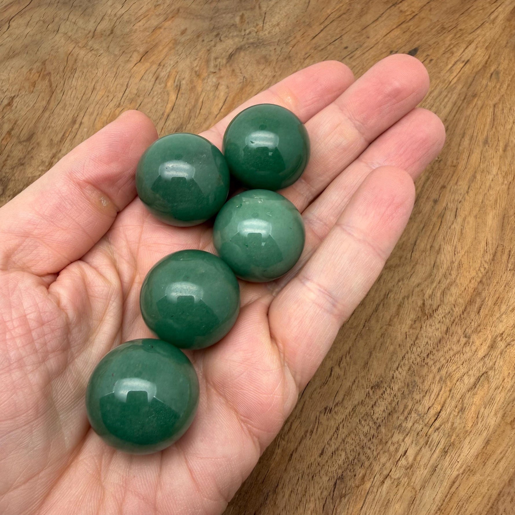 A 25mm aventurine gemstone sphere with smooth, polished green surface and natural stone patterns, perfect for meditation or decor.