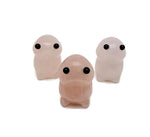 Handcrafted rose quartz frog monster crystal carving from GemstoneGO, detailed gemstone creature statue on a smooth surface.