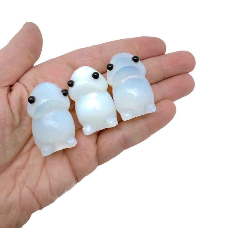 Handcrafted opalite frog monster crystal carving, gemstone creature statue with vibrant colors and detailed features.